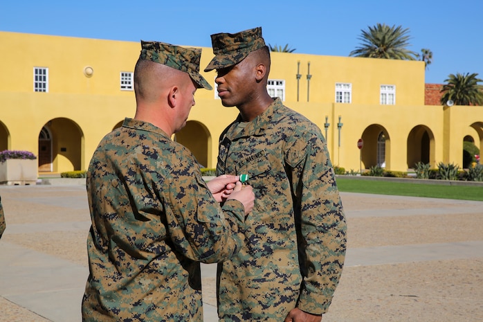 Brigadier General James W. Bierman, commanding general, Marine Corps Recruit Depot San Diego/Western Recruiting Region, awards Cpl. Jason Martin, military police officer, Headquarters and Service Battalion, with the Navy and Marine Corps Commendation Medal at Marine Corps Recruit Depot San Diego, Jan. 5.  Martin received the award for his heroic actions in saving the life of a woman caught in quickly rising flood waters.