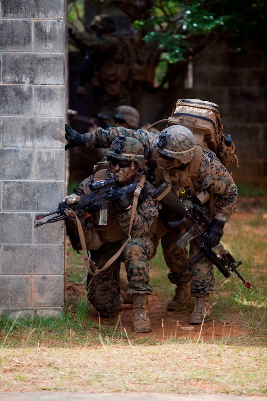 U.S. Marines with Company E, Battalion Landing Team, 2nd Battalion 4th Marines, 31st Marine Expeditionary Unit (MEU), look around a corner during a vertical assault as part of the MEU Exercise (MEUEX), in Combat Town, Okinawa, Japan, Dec 10, 2014. BLT 2/4 is conducting training in preparation of their upcoming spring patrol. (U.S. Marine Corps photo by GySgt Ismael Pena/Released)