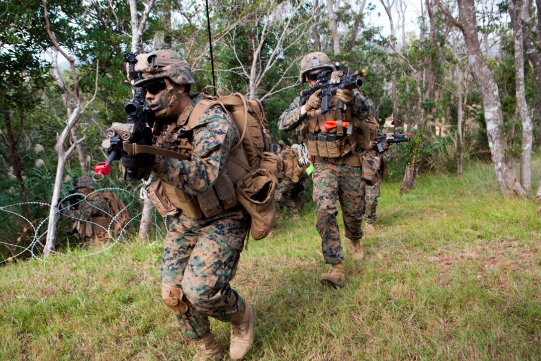 U.S. Marines with Company E, Battalion Landing Team 2nd Battalion, 4th Marines, (BLT) 31st Marine Expeditionary Unit, move towards targets while conducting a vertical assault at Combat Town, Okinawa, Japan, Dec. 8, 2014. Company E is conducting training as part of the MEU Exercise and pre-deployment training. (U.S. Marine Corps Photo by Lance Cpl. Richard Currier/ Released)