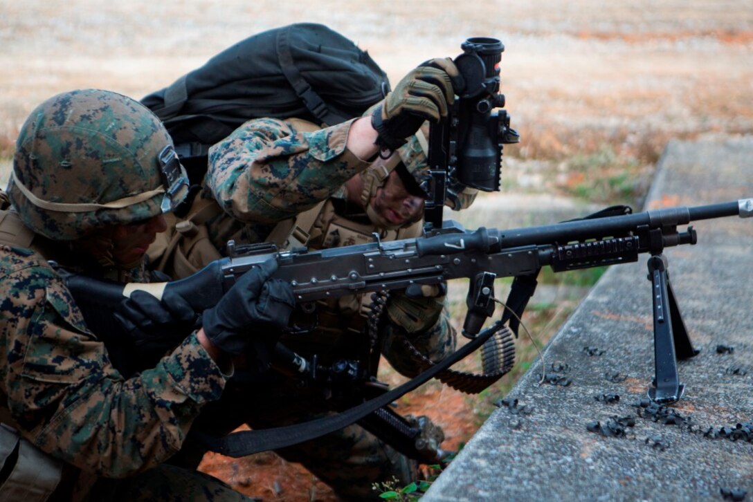 U.S. Marines with Company E, Battalion Landing Team 2nd Battalion, 4th Marines, (BLT) 31st Marine Expeditionary Unit, reload an M240 Machine Gun while conducting a vertical assault at Combat Town, Okinawa, Japan, Dec. 8, 2014. Company E is conducting training as part of the MEU Exercise and pre-deployment training. (U.S. Marine Corps Photo by Lance Cpl. Richard Currier/ Released)