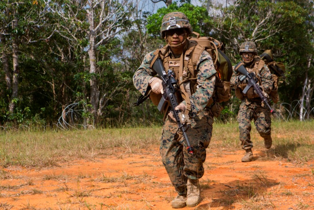 U.S. Marine Corps Lance Cpl. Renea Rivas (front), rifleman, Company E, Battalion Landing Team 2nd Battalion, 4th Marines, (BLT) 31st Marine Expeditionary Unit, moves towards targets while conducting a Helo Raid at Combat Town, Okinawa, Japan, Dec. 8, 2014. Company E is conducting training as part of the MEU Exercise and pre-deployment training. (U.S. Marine Corps Photo by Lance Cpl. Richard Currier/ Released)