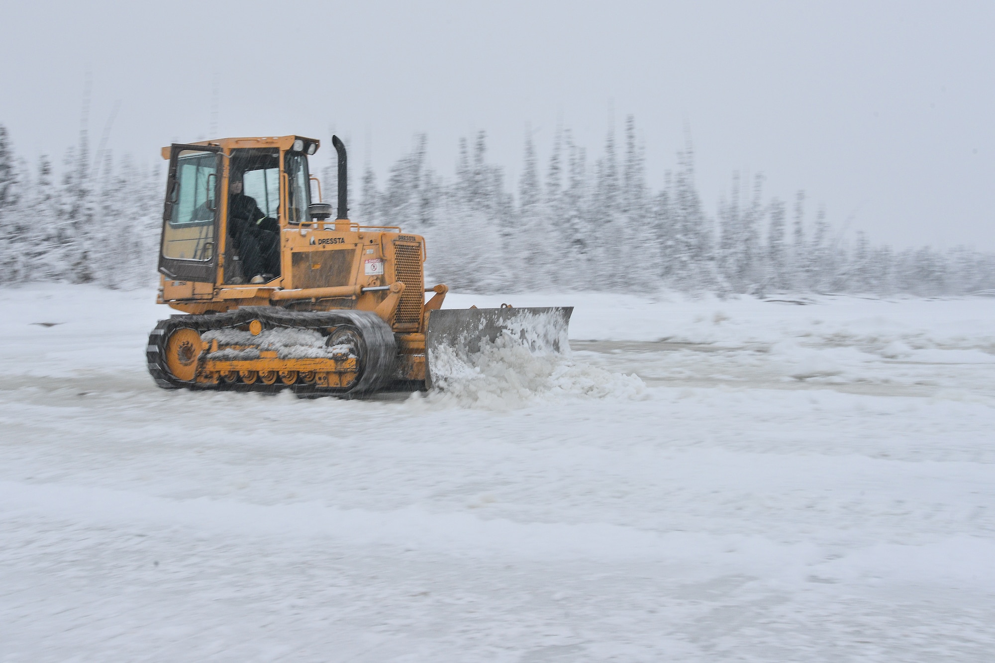 U.S. Air Force Senior Airman Zach Harter, a heavy equipment operator assigned to the 354th Civil Engineer Squadron, uses a bulldozer to build an ice bridge in Fairbanks, Alaska, Dec. 2, 2014. The bridge must be constructed every other year to provide access to the $20 million range complex used to train pilots from around the world during RED FLAG-Alaska exercises.  (U.S. Air Force photo by Tech. Sgt. Joseph Swafford/Released)
