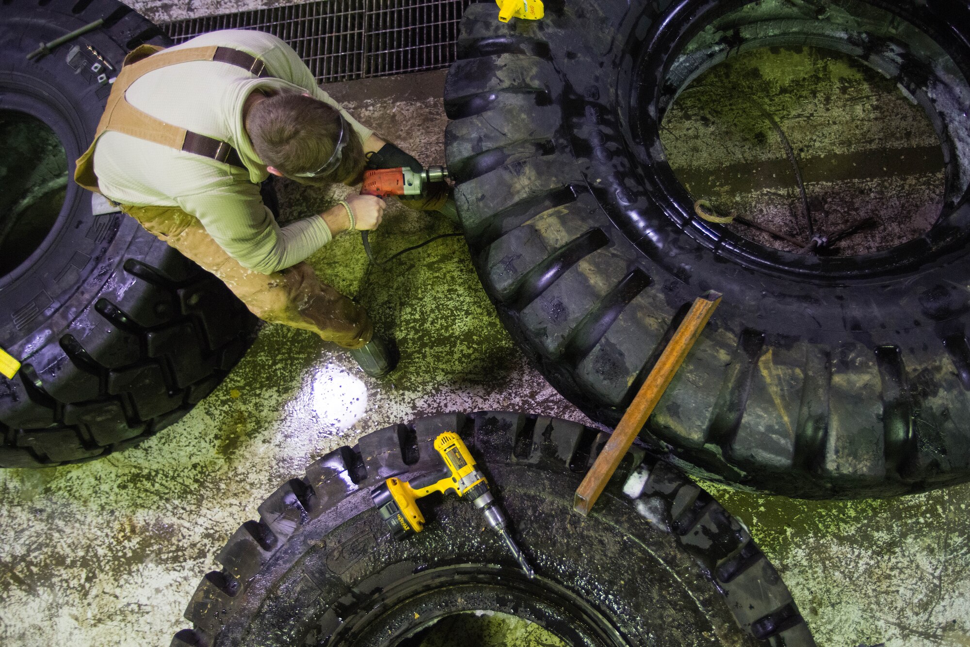 U.S. Air Force Senior Airman John Lee, a range maintenance structures journeyman assigned to the 354th Civil Engineer Squadron, preps a tire to be used to smooth out the service of an ice bridge Dec. 2, 2014, at Eielson Air Force Base, Alaska. The bridge must be constructed every other year to provide access to the $20 million range complex used to train pilots from around the world during RED FLAG-Alaska exercises.  (U.S. Air Force photo by Tech. Sgt. Joseph Swafford/Released)
