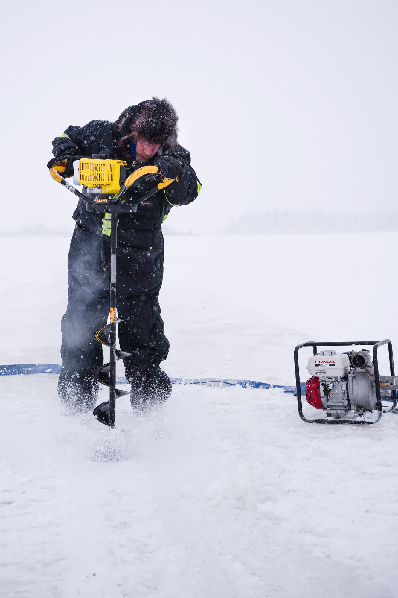 Shawn Kelly, the range maintenance foreman with the 354th Civil Engineer Squadron, uses an ice auger while constructing a ice bridge in Fairbanks, Alaska, Dec. 4, 2014. The bridge must be constructed every other year to provide access to the $20 million range complex used to train pilots from around the world during RED FLAG-Alaska exercises.  (U.S. Air Force photo by Staff Sgt. Shawn Nickel/Released)
