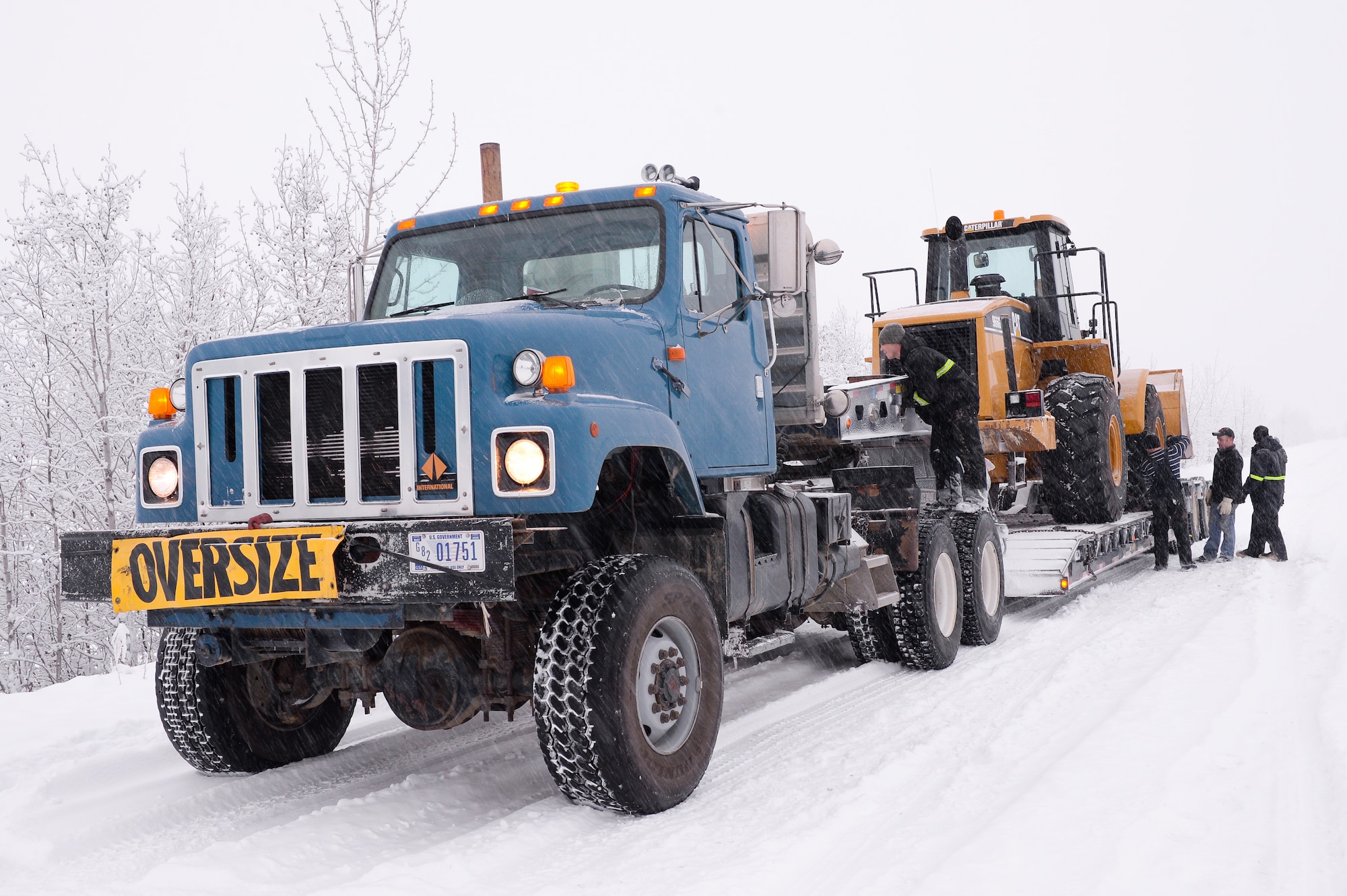 Members of the 354th Civil Engineer Squadron unload a tractor to be used in constructing an ice bridge in Fairbanks, Alaska, Dec. 2, 2014. The bridge must be constructed every other year to provide access to the $20 million range complex used to train pilots from around the world during RED FLAG-Alaska exercises.  (U.S. Air Force photo by Staff Sgt. Shawn Nickel/Released)
