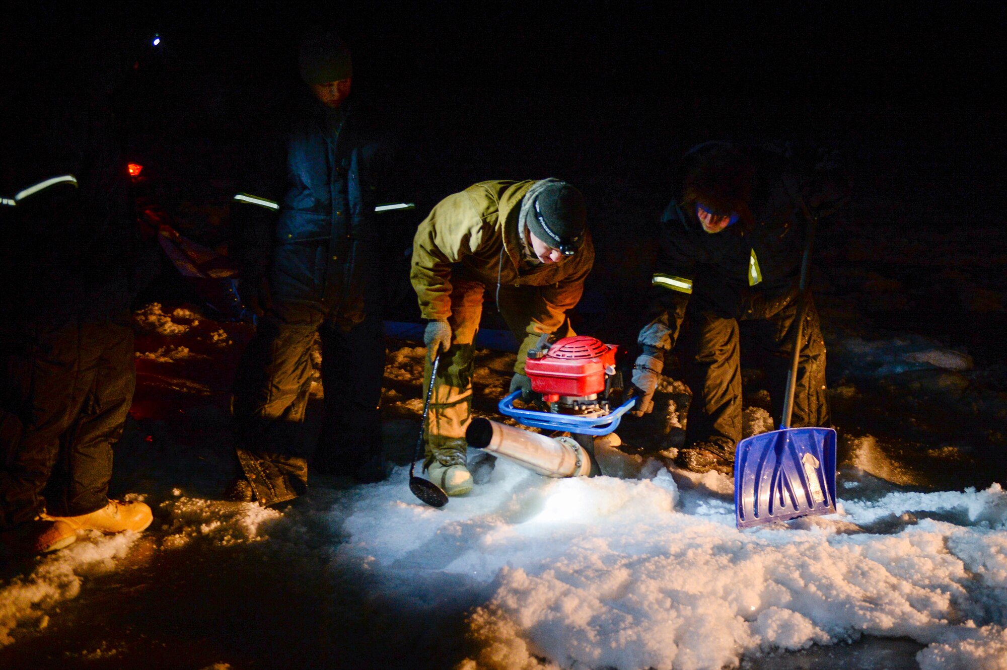 Members of the 354th Civil Engineer Squadron prepare a water pump during the construction of an ice bridge in Fairbanks, Alaska, Nov. 20, 2014. The bridge must be constructed every other year to provide access to the $20 million range complex used to train pilots from around the world during RED FLAG-Alaska exercises.  (U.S. Air Force photo by Staff Sgt. Shawn Nickel/Released)
