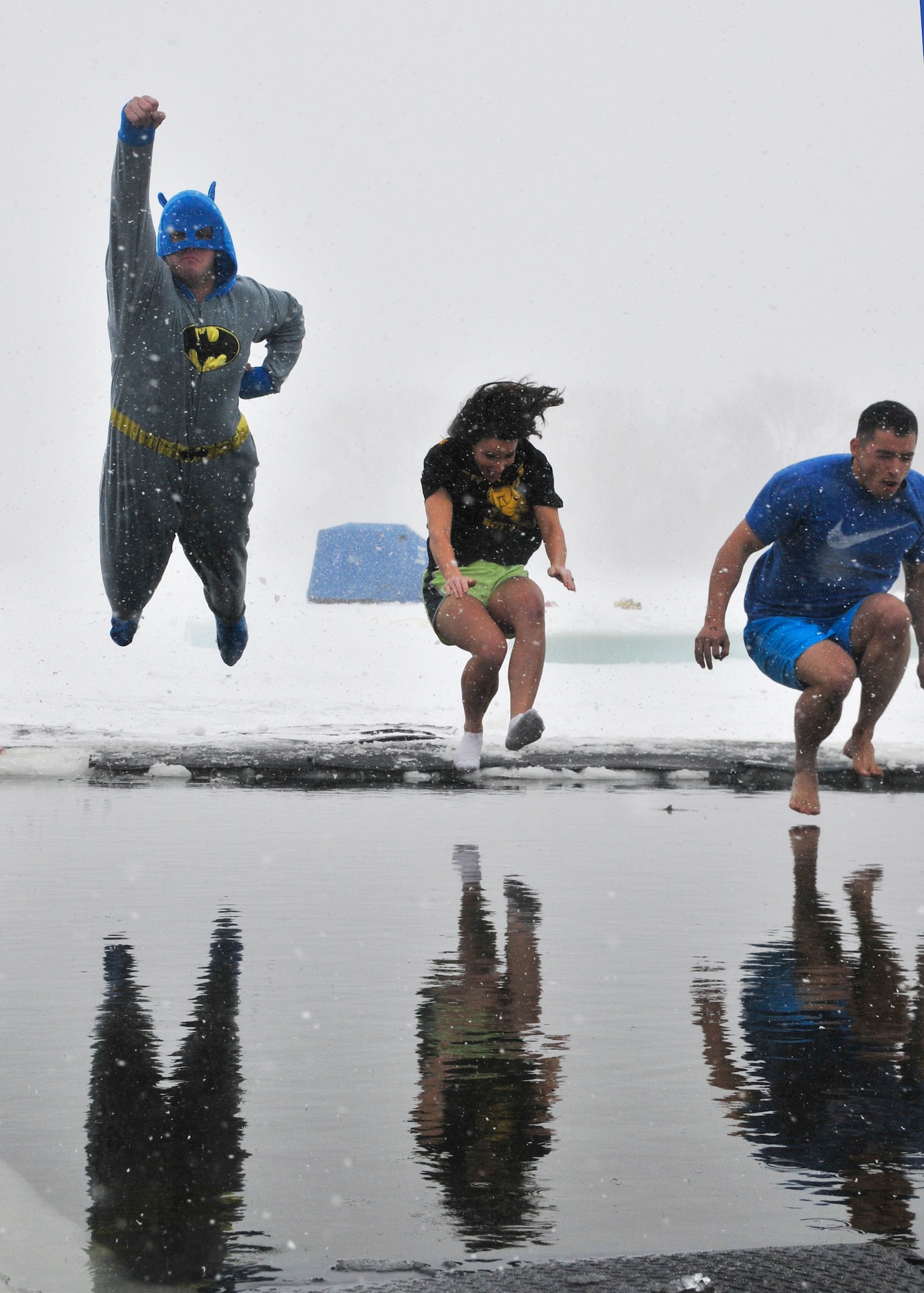 One of 23 teams jumps into the icy waters of Sloans Lake, Cheyenne, Wyo., during the third annual Schwartz Memorial Plunge, Jan. 3, 2015. All proceeds raised from the event were donated to the EOD Warrior Foundation, which  provides financial assistance and support to wounded and fallen explosive ordnance disposal warriors and their families. (U.S. Air Force photo/Lan Kim)
