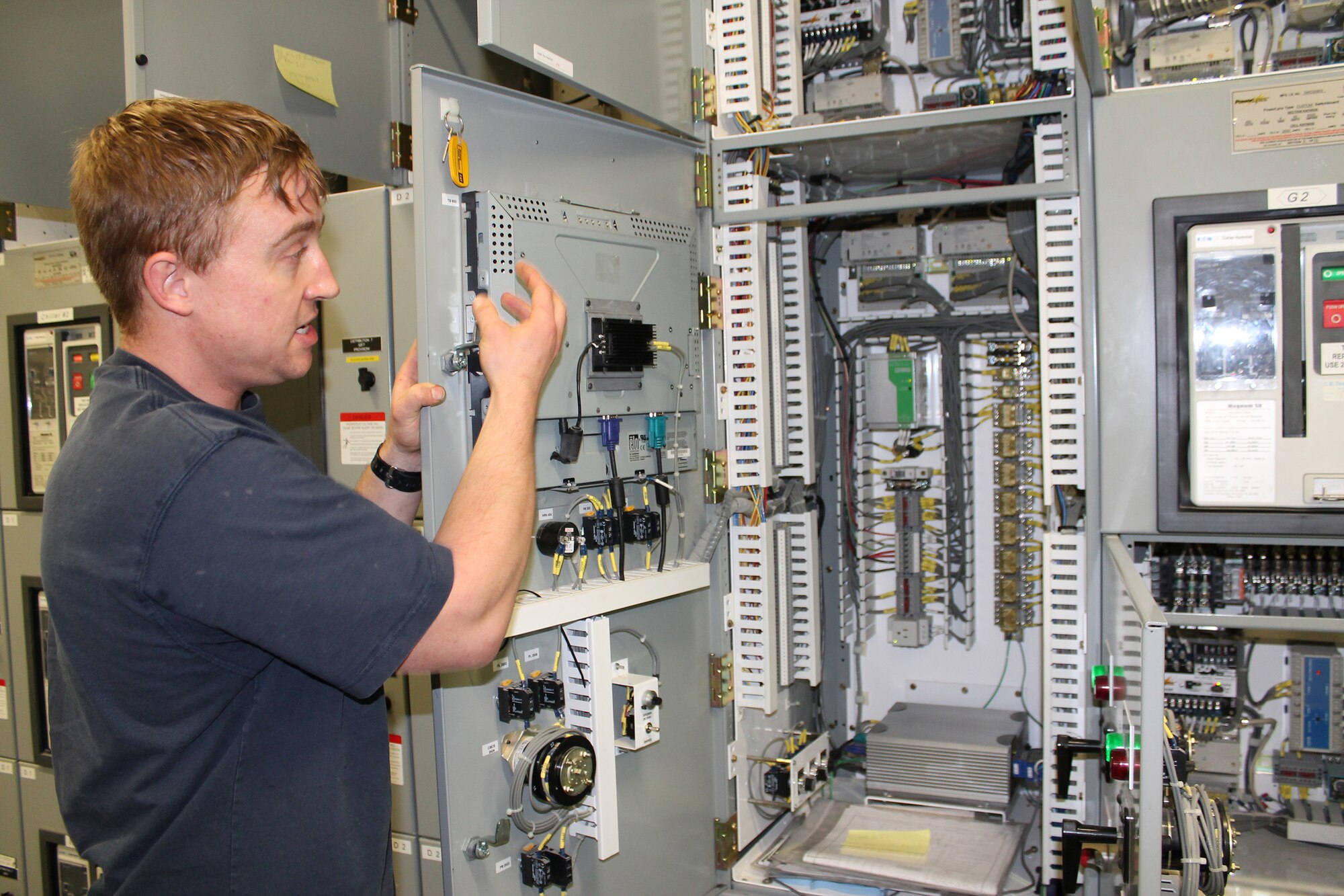 Jayson Shafer, Base Operations Support electrical technician, explains the critical role the switch gear plays in maintaining Keesler Medical Center’s air, gas and water systems Dec. 16, 2014, at Keesler Air Force Base, Miss. This cutting-edge, hybrid system is one of the most unique and advanced systems being used worldwide.  (Courtesy photo by Lisa Campbell)