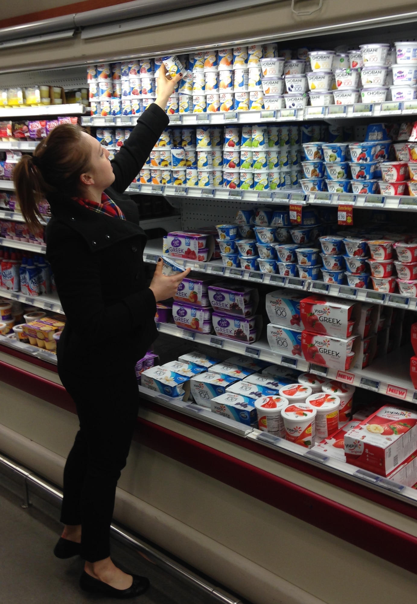 PETERSON AIR FORCE BASE, Colo. -- Tiffany Brunton, 21st Medical Group health promotion dietician, looks for yogurt with less sugar. Brunton recommends lower sugar varieties or purchasing plain yogurt and adding your own fresh fruit for a healthier choice. Examining food labels makes healthy selections throughout the store simple. (U.S. Air Force photo by Dave Smith)
