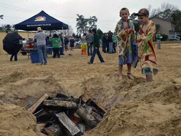Participants warm up next to a fire pit on the beach after their plunge into Lake Moultrie as part of the inaugural Polar Plunge at the Joint Base Charleston Short Stay Recreation Area, Jan. 3, 2014. (U.S. Air Force photo/Jessica Donnelly)
