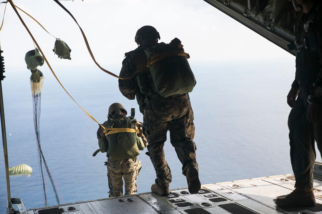IE SHIMA, OKINAWA, Japan — Marines static line jump out of a KC-130J Super Hercules aircraft Nov. 20, 2014 over Ie Shima Training Facility, off the northwest coast of Okinawa, Japan. While performing a low level static line jump, the jumper is released from the aircraft at a low altitude and their chute is pulled open by the aircraft as they exit. The Marines did their static line jumps from an altitude of 1,500 feet for this training. The Marines are with 3rd Reconnaissance Battalion, 3rd Marine Division, III Marine Expeditionary Force. 