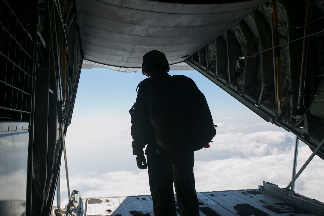 Gunnery Sgt. Matthew Bateman peers out the rear of a KC-130J Super Hercules aircraft Nov. 20, 2014 over Ie Shima Training Facility, off the northwest coast of Okinawa, Japan. Marines with 3rd Reconnaissance Battalion took part in parachute training, keeping them proficient and current with their jump qualifications. Bateman, from Gaithersburg, Maryland, is a reconnaissance man and jumpmaster with 3rd Recon Bn., 3rd Marine Division, III Marine Expeditionary Force. 