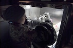 Tech. Sgt. Charlotte Koshek analyzes a sample drawn from a "contaminated" room in the VIP Lodge at Alpine Valley Music Theatre during an Army North external evaluation of the Wisconsin National Guard's 54th Civil Support Team on March 25, 2010. The evaluation is required every 18 months for unit certification. In the exercise scenario, a winter concert by rock groups promoting animal cruelty was sabotaged with chemical, biological and radiological materials by an animal rights group.