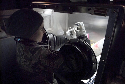 Tech. Sgt. Charlotte Koshek analyzes a sample drawn from a "contaminated" room in the VIP Lodge at Alpine Valley Music Theatre during an Army North external evaluation of the Wisconsin National Guard's 54th Civil Support Team on March 25, 2010. The evaluation is required every 18 months for unit certification. In the exercise scenario, a winter concert by rock groups promoting animal cruelty was sabotaged with chemical, biological and radiological materials by an animal rights group.