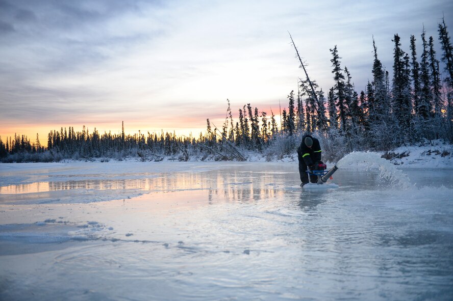 Senior Airman Jerry Mitchell uses a water pump Nov. 20, 2014, while constructing an ice bridge in Fairbanks, Alaska. The bridge must be constructed every other year to provide access to the $20 million range complex used to train pilots from around the world during Red Flag-Alaska exercises. Mitchell is a heavy equipment operator with the 354th Civil Engineer Squadron on Eielson Air Force Base, Alaska.  (U.S. Air Force photo/Staff Sgt. Shawn Nickel)