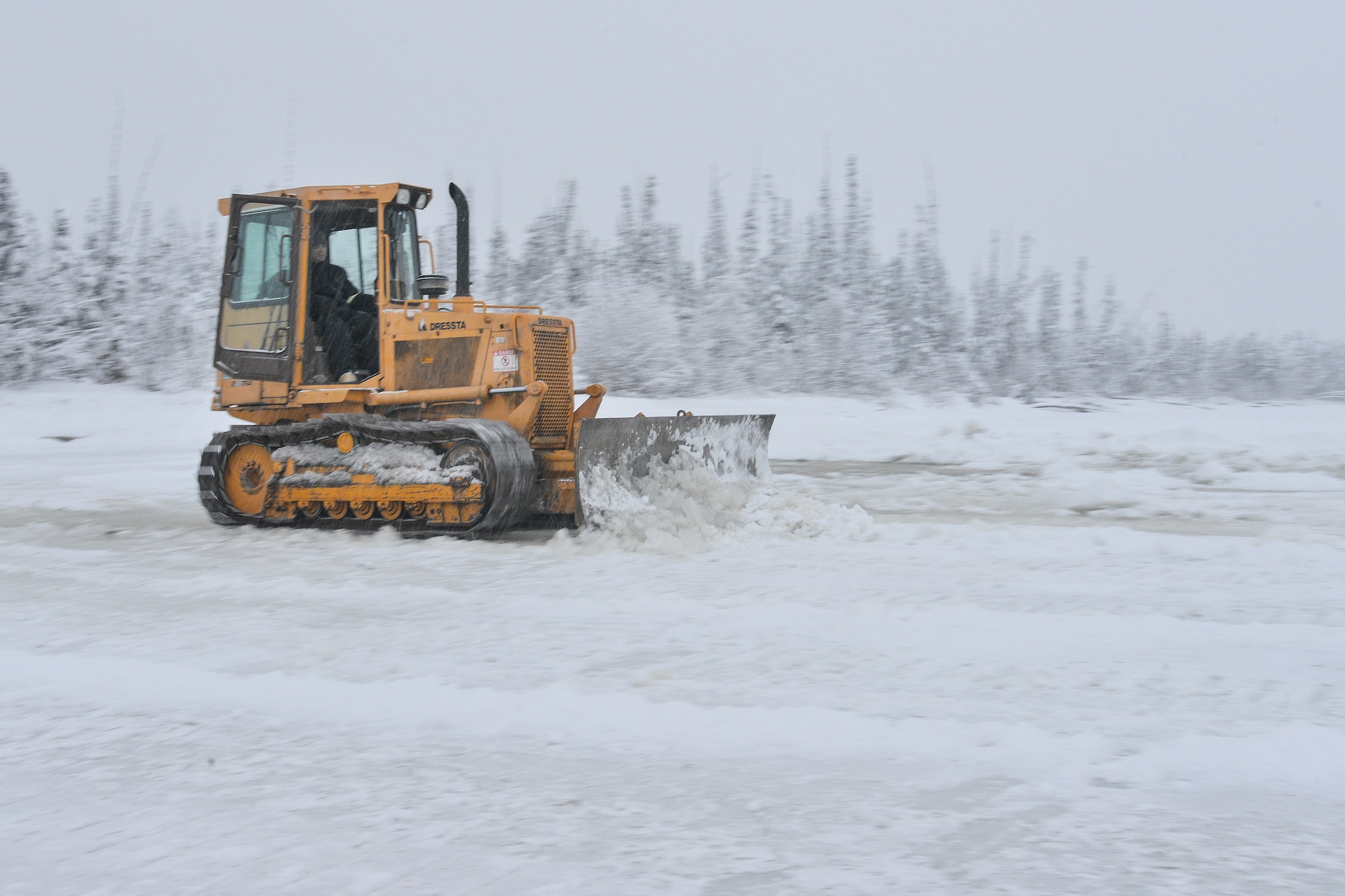 Senior Airman Zach Harter uses a bulldozer to build an ice bridge Dec. 2, 2014, in Fairbanks, Alaska. The bridge must be constructed every other year to provide access to the $20 million range complex used to train pilots from around the world during Red Flag-Alaska exercises. Harter is a heavy equipment operator assigned to the 354th Civil Engineer Squadron on Eielson Air Force Base, Alaska. (U.S. Air Force photo/Tech. Sgt. Joseph Swafford)