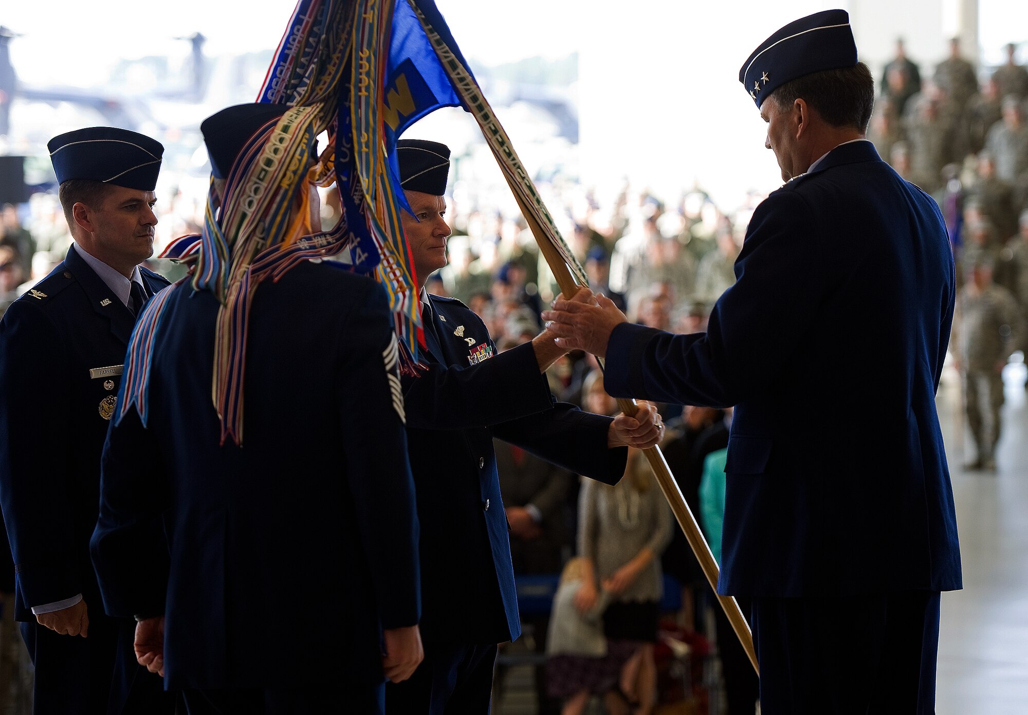 Col. Bill West, middle, outgoing 1st Special Operation Wing commander, presents the 1st SOW guidon to Lt. Gen. Bradley A. Heithold, Air Force Special Operations Command commander during a change of command ceremony here, Jan. 6, 2015. Col. Sean Farrell assumed command of the 1st SOW from Col. Bill West during the ceremony. (U.S. Air Force photo/Staff Sgt. Kentavist P. Brackin)