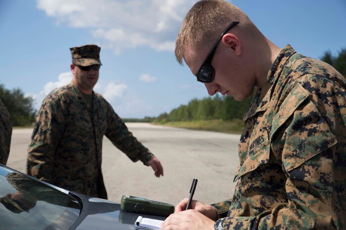 Lance Cpl. James H. Lovett writes down coordinates to an expeditionary runway Dec. 18 during exercise Marine Logistics Group Crisis Action Module Rehearsal Guam, or MCR Guam, near Anderson Air Force Base. MCR Guam is a scenario-run exercise that utilizes an expeditionary command-and-control center as well as members of a survey, liaison and reconnaissance party. Lovett, who participated during the exercise as a member of the SLRP, constantly wrote down and plotted location coordinates on a grid during the reconnaissance patrol. Lovett, from Honolulu, Hawaii, is a logistics clerk with the 3rd Marine Logistics Group, III Marine Expeditionary Force. (U.S Marine Corps photo by Cpl. Matt S. Myers/Released)