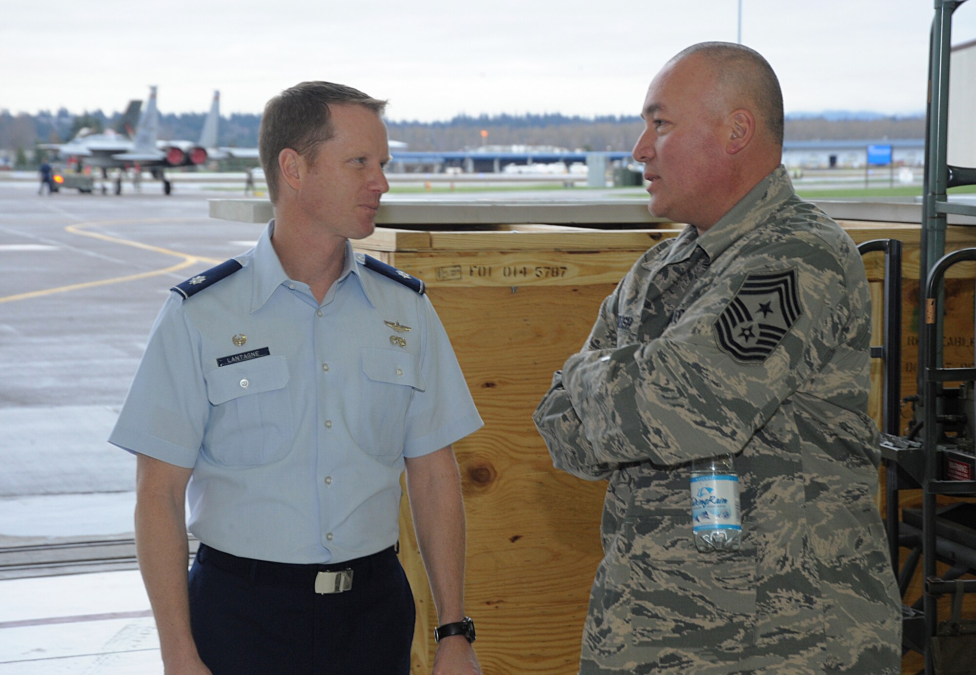 Lt. Col. Christopher Lantagne, 142nd Fighter Wing Aircraft Maintenance Squadron commander, left, talks with Chief Master Sgt. Mitchell O. Brush, Senior Enlisted Advisor for the National Guard Bureau, right, during his tour of the Portland Air National Guard Base, Ore., Jan. 5, 2015. Chief Brush took time to meet Airmen in various areas of the air base to get a better understanding of their roles as members of the Air National Guard. (U.S. Air National Guard photo by Tech. Sgt. John Hughel, 142nd Fighter Wing Public Affairs/Released)
