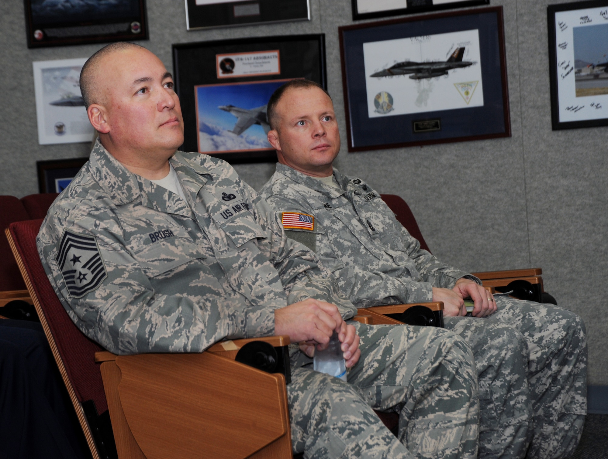 Chief Master Sgt. Mitchell O. Brush, Senior Enlisted Advisor for the National Guard Bureau, left, and SGM Shane Lake, Oregon National Guard Senior Enlisted Advisor, right, listen to remarks from senior enlisted leaders from the 142nd Fighter Wing during a briefing at the Portland Air National Guard Base, Ore., Jan. 5, 2015. Chief Brush toured the air base and led a town hall event to highlight the changes and challenges that Soldiers and Airmen of the National Guard face going into the New Year. (U.S. Air National Guard photo by Tech. Sgt. John Hughel, 142nd Fighter Wing Public Affairs/Released)