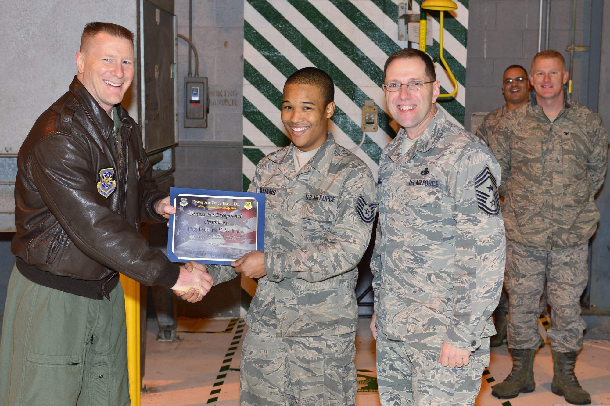 Col. Michael Grismer, 436th Airlift Wing commanders STEP promotes Tech. Sgt. Damaris Williams, 436th Maintenance Squadron assistant NCO in charge of wheel and tire, Dec. 24, 2014, at Dover Air Force Del. Williams was recognized for his leadership abilities and outstanding work ethic by his supervision. (U.S. Air Force photo/Airman 1st Class Zachary Cacicia)