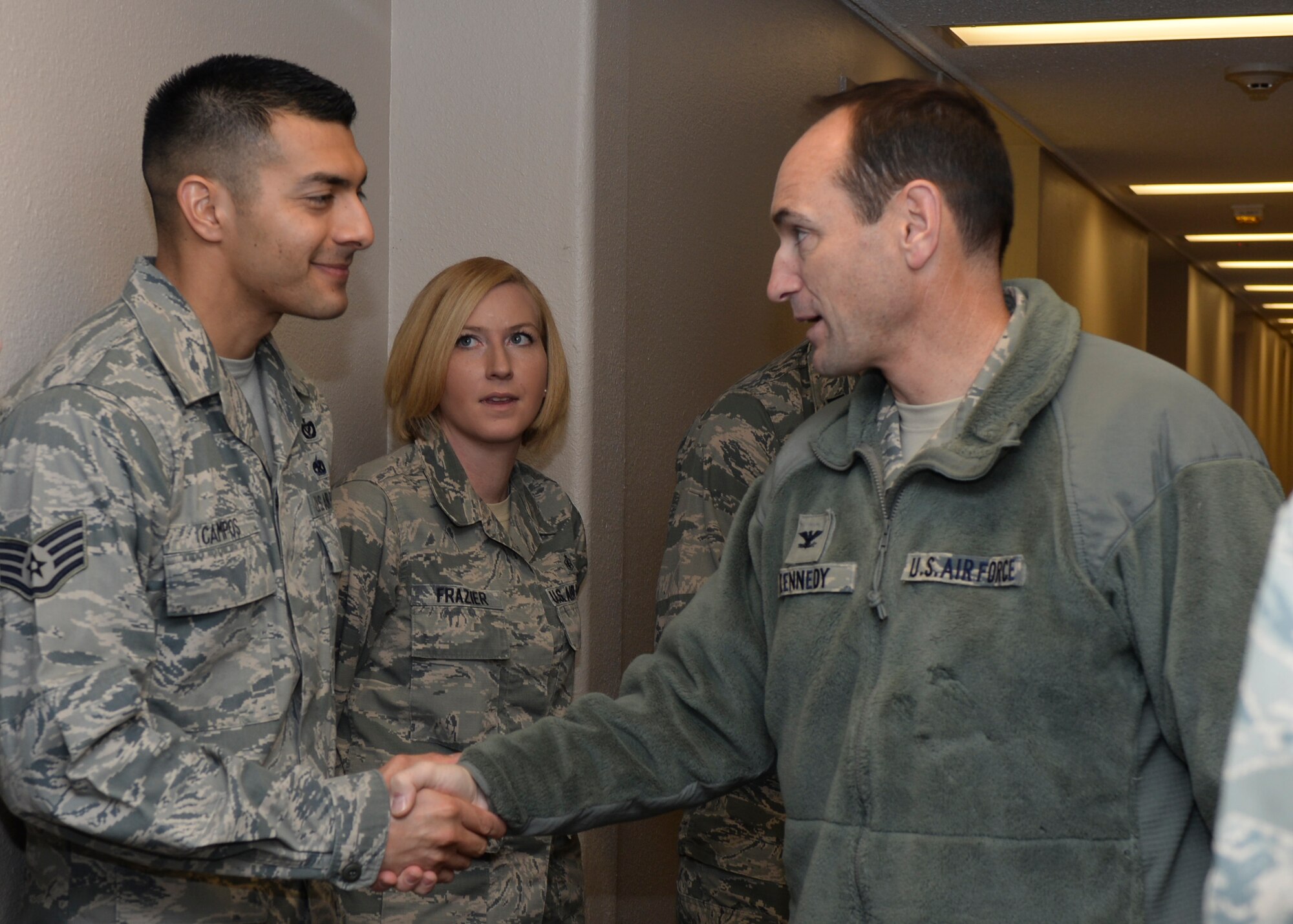 Col. Kevin Kennedy, 28th Bomb Wing commander, thanks Staff Sgts. Marcos Campos (left) and Crystal Frazier (right), 28th Civil Engineer Squadron Airmen dormitory leaders, for their hard work as part of the renovation to the base dorm kitchenettes at Ellsworth Air Force Base, S.D., Dec. 22, 2014. Contingency construction projects improve the quality of life for Ellsworth Airmen while ensuring mission readiness for those involved. . (U.S. Air Force photo by Senior Airman Anania Tekurio/Released)   