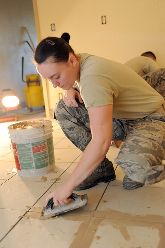 Airman 1st Class Cassandra Nielsen, 28th Civil Engineer Squadron structural apprentice, grouts tile during a dormitory kitchenette renovation at Ellsworth Air Force Base, S.D., Dec. 10, 2014. The 28th CES Airmen have been hard at work remodeling two dormitory kitchenettes, ensuring each room is uniform with previous dormitory renovations as part of a contingency construction project, which enhances the quality of life aspect in Airmen dormitories. (U.S. Air Force photo by Senior Airman Hailey R. Staker)