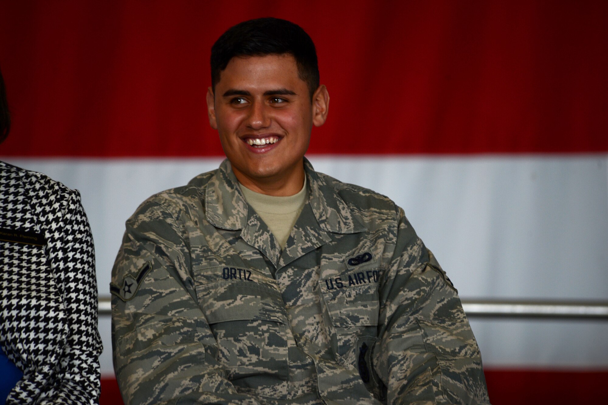U.S. Air Force Airman Daniel Ortiz, 20th Security Forces Squadron entry controller, smiles while sitting on stage during an all-call at Shaw Air Force Base, S.C., Jan. 6, 2015. Col. Stephen Jost, 20th Fighter Wing commander, gave examples of his new initiative “Airman Up” by speaking about eight Team Shaw members who have already shown resiliency and personal development. (U.S. Air Force photo by Senior Airman Jensen Stidham/Released)   