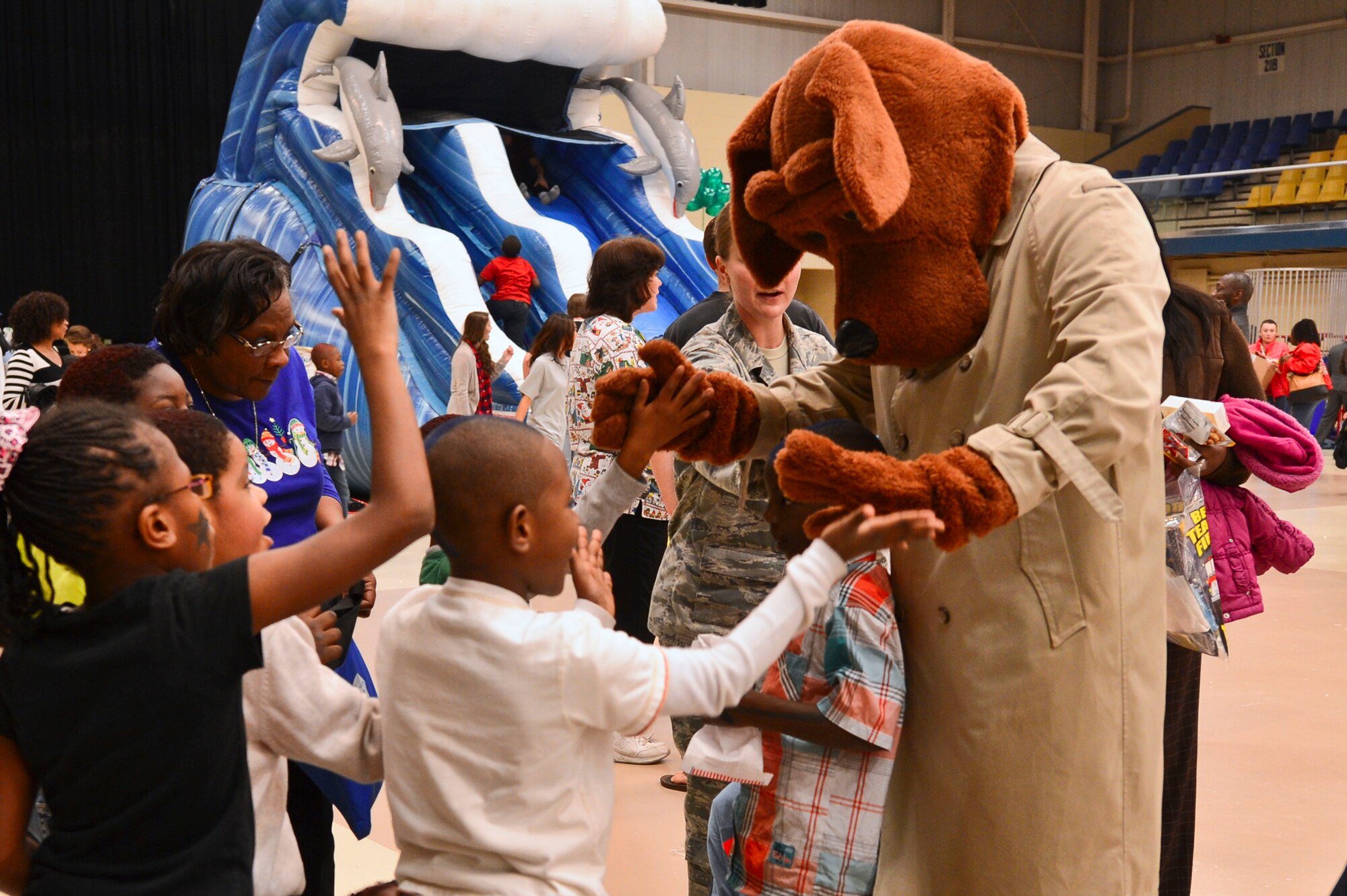 McGruff the Crime Dog, high-fives children during a “Winter Wonderland” themed event at the Sumter Civic Center, Sumter, S.C., Dec. 19, 2014. The event was held for children with special needs and included inflatables face painting, and wagon and train rides, which helped the children with their fine and gross motor skills. (U.S. Air Force photo by Senior Airman Tabatha Zarrella/Released)