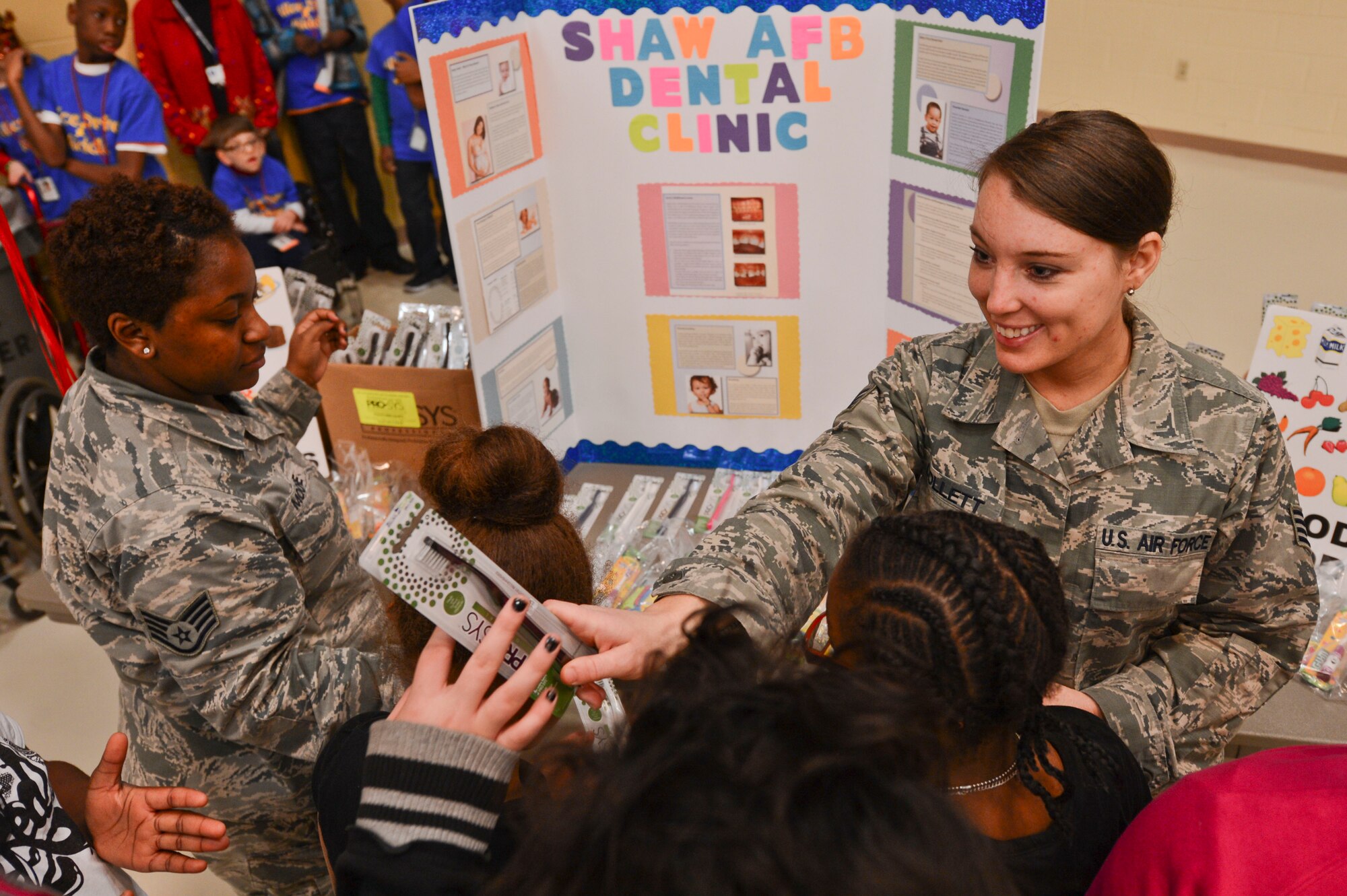 U.S. Air Force Staff Sgt. Tonya Collett, 20th Dental Squadron technician, hands a toothbrush to a child during a “Winter Wonderland” themed event at the Sumter Civic Center, Sumter, S.C., Dec. 19, 2014. Shaw Air Force Base Airmen participated in the event which was hosted for local area children with special needs, giving them a day filled with activities. (U.S. Air Force photo by Senior Airman Tabatha Zarrella/Released)