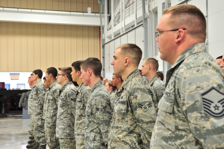5th Maintenance Squadron Airmen listen to a speech at a Ribbon Cutting Ceremony on Minot Air Force Base, N.D., Dec. 12, 2014. Construction began on the new Aerospace Ground Equipment flight’s munition handling trailer maintenance facility in November 2013 to increase the bay’s capacity. (U.S. Air Force photo/Senior Airman Malia Jenkins)