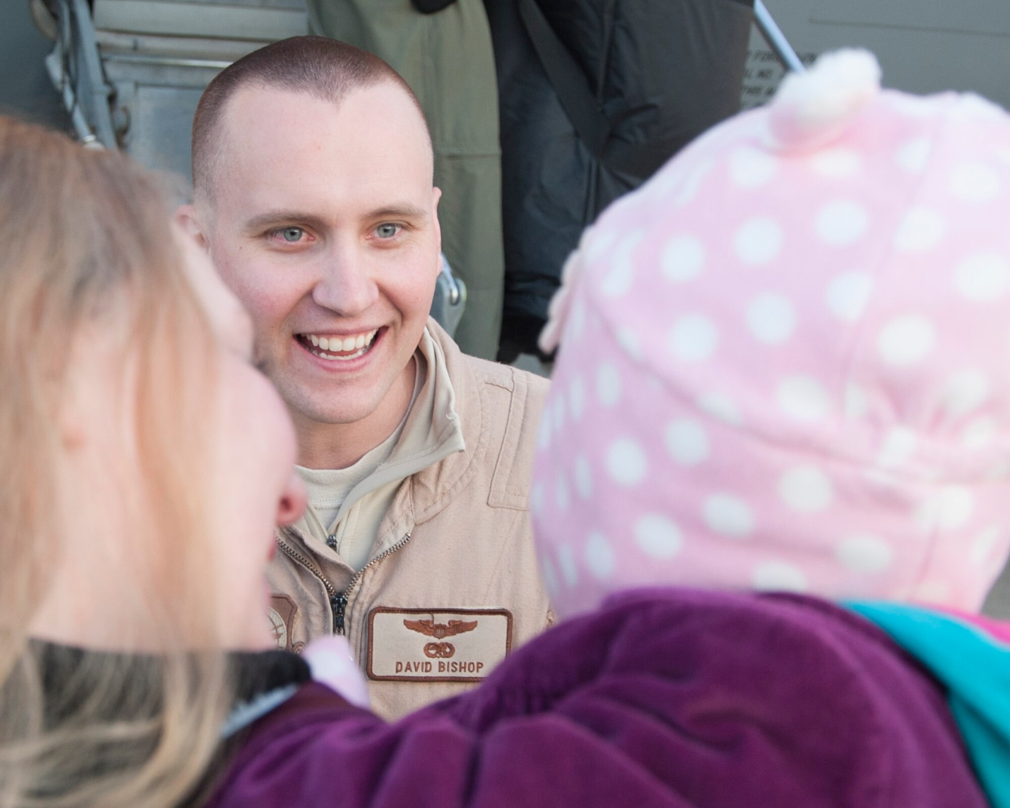 Capt. David Bishop, 3d Airlift Squadron C-17 Globemaster III pilot, prepares to receive a warm welcome from his wife and daughter Dec. 31, 2014, on Dover Air Force Base, Del. Bishop was the aircraft commander while deployed to Romania in support of the retrograde mission in Afghanistan. (U.S. Air Force photo/Senior Airman Jared Duhon)