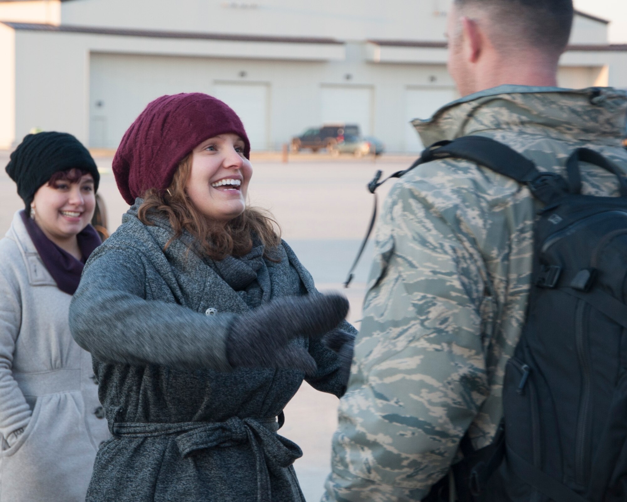 Staff Sgt. Elizabeth Morris, 436th Airlift Wing Public Affairs photojournalist, greets her husband, Staff Sgt. Clayton Morris, 436th Operations Support Squadron aircrew flight equipment, Dec. 31, 2014, on Dover Air Force Base, Del. Morris was deployed to Romania in support of the retrograde in Afghanistan, in which troops and equipment were transported out of the country. (U.S. Air Force photo/Senior Airman Jared Duhon)