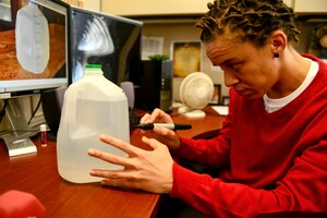 Amber Hendricks, Army Support Activity mortuary affairs coordinator, makes time marks on a gallon of water at Fort Eustis, Va., Jan. 5, 2015. Hendricks, has set a personal goal for the new year to drink a gallon of water every day as a way to become healthier. Hendricks’ goal is to also find ways to stay active even at her desk by stretching frequently and using small dumbbells. (U.S. Air Force photo by Senior Airman Kimberly Nagle/Released)  