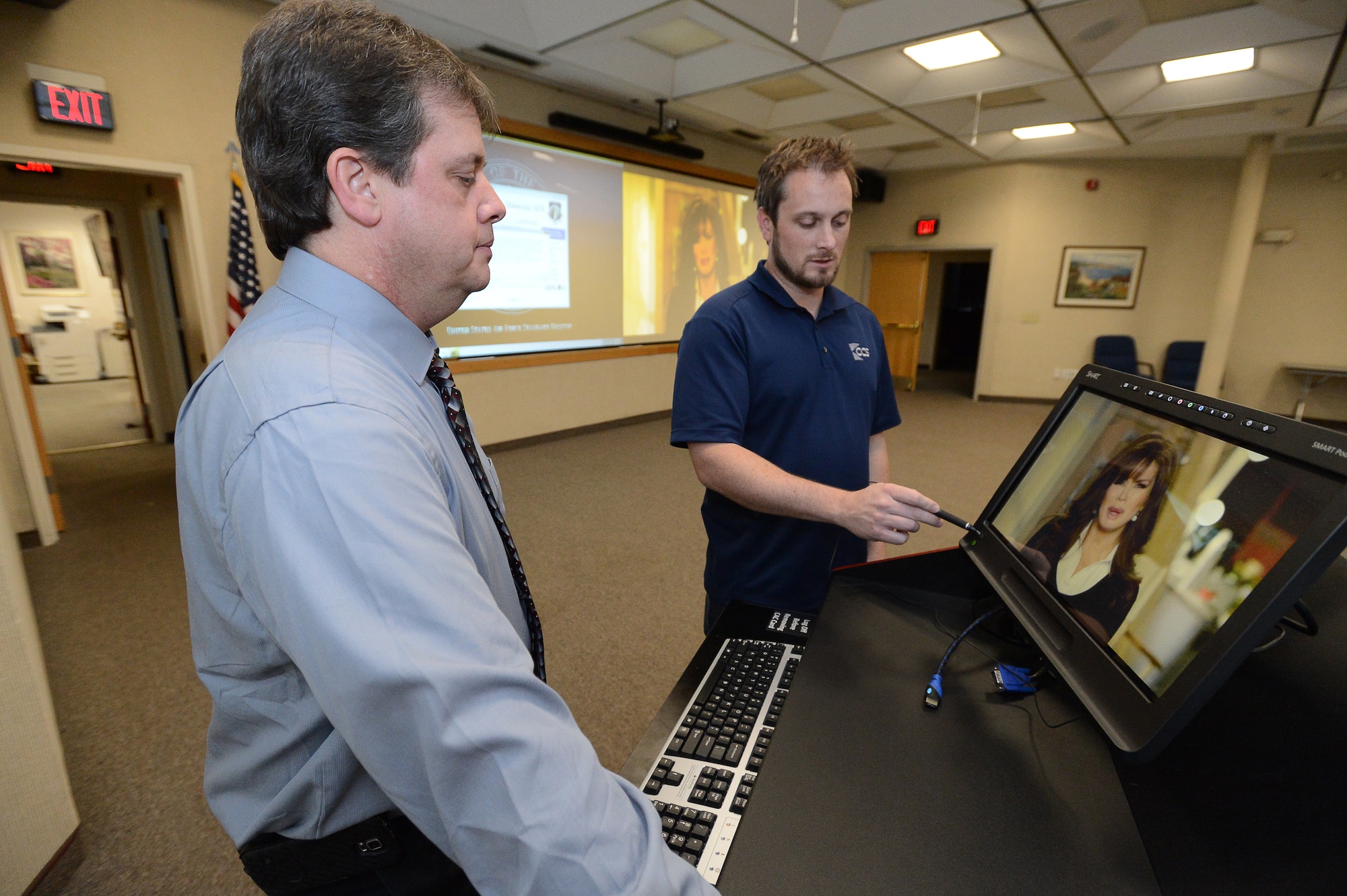 Brandon Meyers, lead project manager, CCS Presentation Systems, describes some of the features of the podium mounted control panel to Donn DeSilva, 66th Communications and Information Division information technology help desk specialist, inside the Hanscom Conference Center’s Concord Room Dec. 30. Hanscom Conference Center officials recently announced that an upgrade to the audio visual equipment in the Lexington Amphitheater and Concord Room is complete and that a ribbon cutting and open house is scheduled Jan. 20 from 1 to 3 p.m. to mark the occasion.  (U.S. Air Force photo by Jerry Saslav)