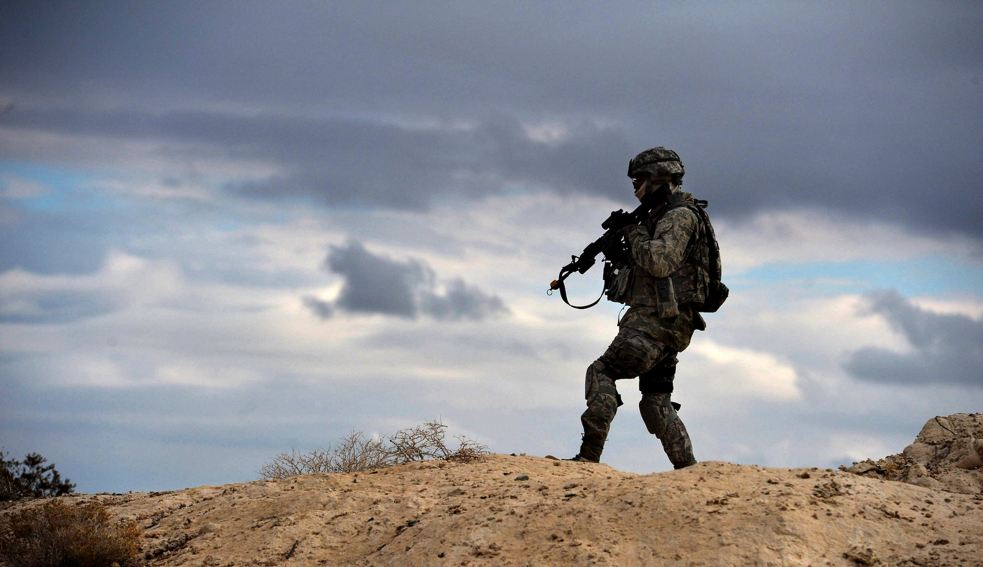 Staff Sgt. Dontea White scans the area around his convoy for simulated explosive ordnance devices during the dismounted operations portion of the course Dec. 17, 2014, at the Silver Flag Alpha Range Complex, Nev. White is a Base Security Operations course student training for his first deployment and is currently assigned to the 512th Security Forces Squadron at Dover Air Force Base, Delaware. (U.S. Air force photo/Tech. Sgt. Nadine Barclay)