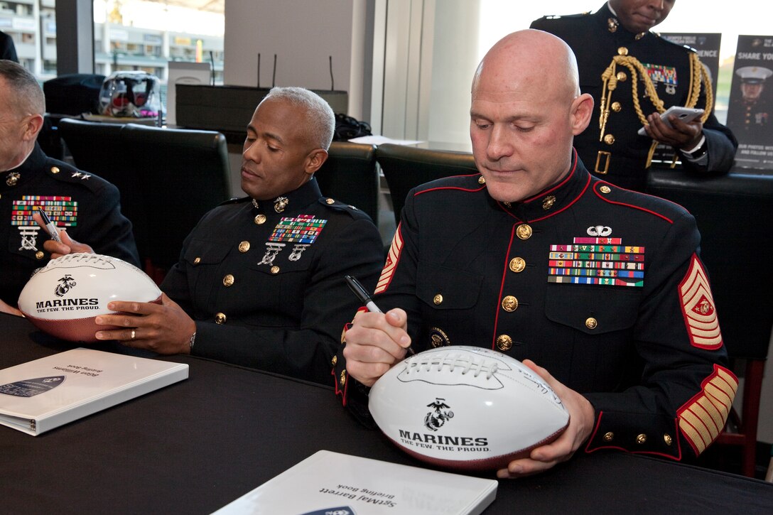 Sgt. Maj. Micheal P. Barrett, the 17th Sergeant Major of the Marine Corps, signs a football for the players of the 2015 Semper Fidelis All-American Bowl, at the StubHub Center, Carson, Calif., on Jan. 4, 2015. (U.S. Marine Corps photo by Lance Cpl. Samantha K. Draughon/ Released) 