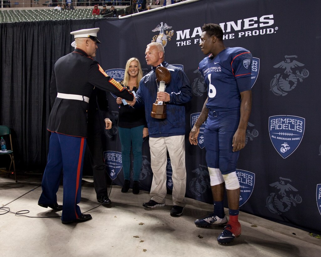 Sgt. Maj. Micheal P. Barrett, the 17th Sergeant Major of the Marine Corps, presents the trophy to Semper Fi East Team Head Coach Rich Hansen at the 2015 Semper Fidelis All-American Bowl, at the StubHub Center, Carson, Calif., on Jan. 4, 2015. (U.S. Marine Corps photo by Lance Cpl. Samantha K. Draughon/ Released)