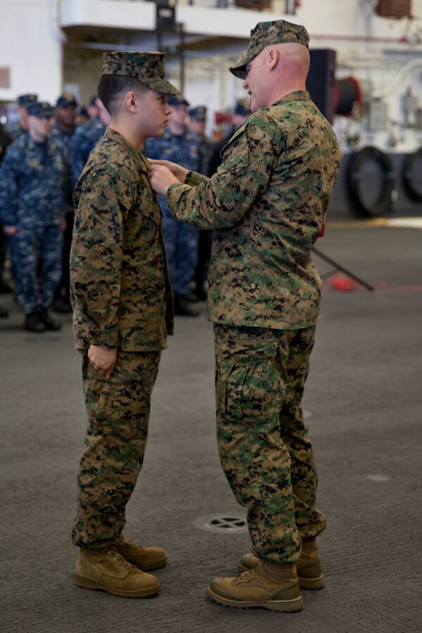 Sgt. Maj. Micheal P. Barrett, the 17th Sergeant Major of the Marine Corps, congratulates newly promoted Sgt. Marcos Gutierrez at his promotion ceremony aboard the USS America (LHA-6), at Naval Base San Diego, Calif., on Jan. 5, 2015. (U.S. Marine Corps photo by Lance Cpl. Samantha K. Draughon/ Released) 