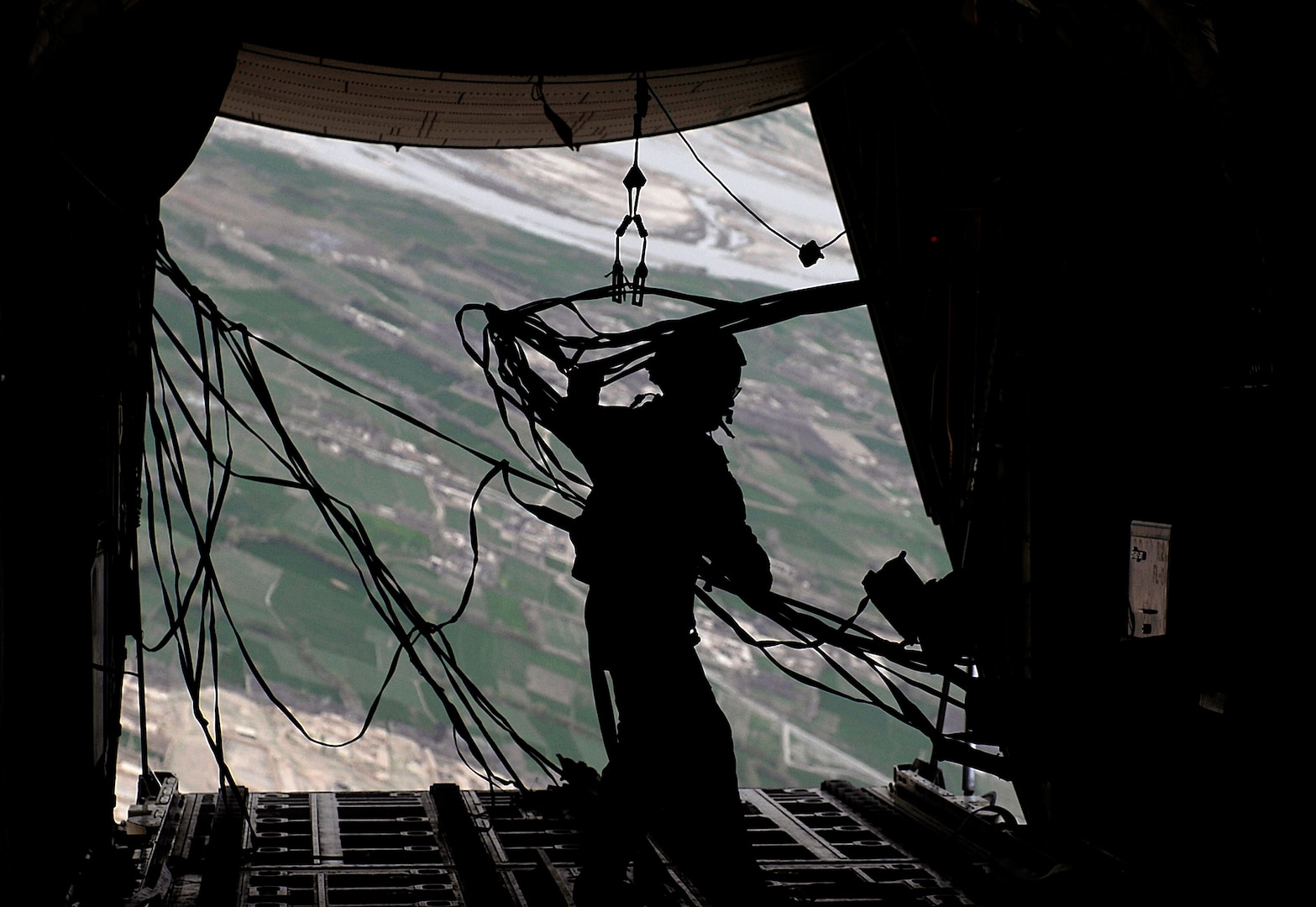 Senior Master Sgt. Thomas Kelly retrieves static lines after his second airdrop of the day over Afghanistan March 2, 2010. Kelly is deployed from the Maryland Air National Guard's 135th Airlift Squadron, based in Baltimore, Md.
