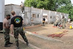 Staff Sgt. Marcel Prude and Master Sgt. Jeff Talaga, members of the 127th
Civil Engineering Squadron of the Michigan Air National Guard, look over the
job site at Akota air base in Accra, Ghana, April 12, 2010. The 127th CES
deployed to Ghana for two weeks in April to help perform a major renovation
on this training building used by the air force of Ghana.
