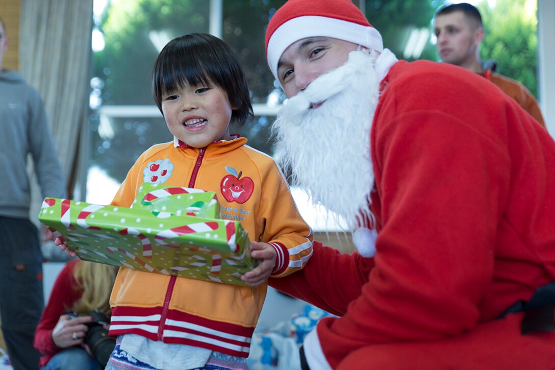 A volunteer from Marine Corps Air Station Iwakuni, Japan, hands out toys during a visit to a children’s home in Hofu, Japan, Dec. 23, 2014. The Marine Thrift Store hosted the visit after collecting toys during a toy drive and motorcycle rally earlier this year. The rally collected more than 300 toys to give to the children’s home.