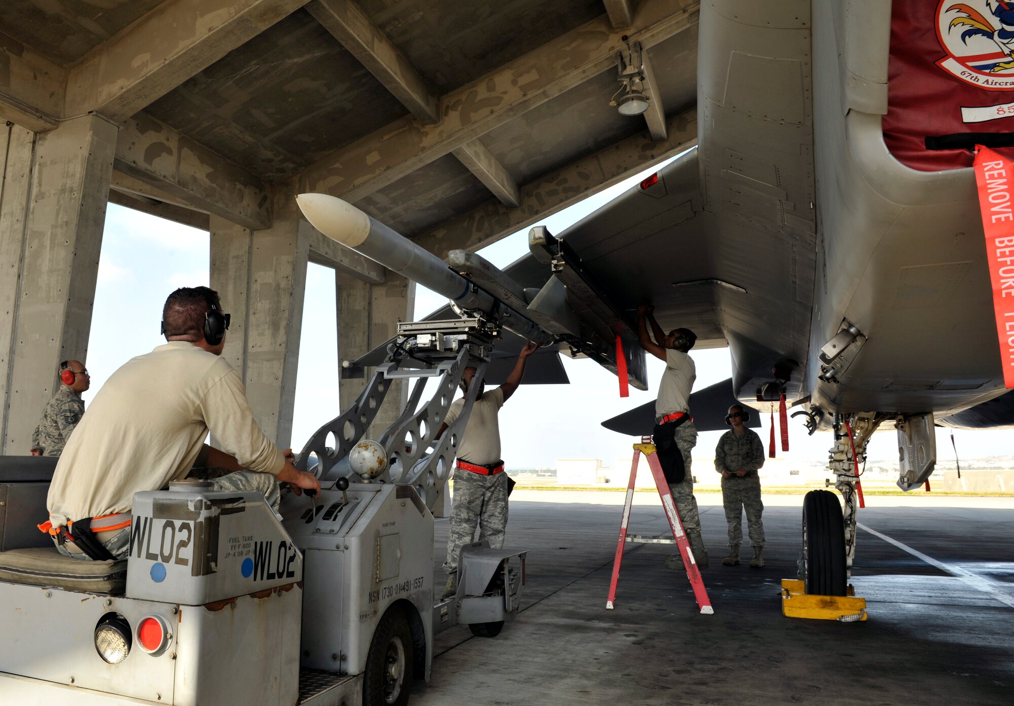 A U.S. Air Force weapons load crew team from the 67th Aircraft Maintenance Unit attaches an AIM-120 advanced medium-range air-to-air missile onto an F-15 Eagle during a quarterly weapons load competition on Kadena Air Base, Japan, Jan. 5, 2015. Each team must load an AIM-9L/M Sidewinder missile and an AIM-120 advanced medium-range air-to-air missile onto an F-15 Eagle aircraft with speed and precision. (U.S. Air Force photo by Naoto Anazawa)