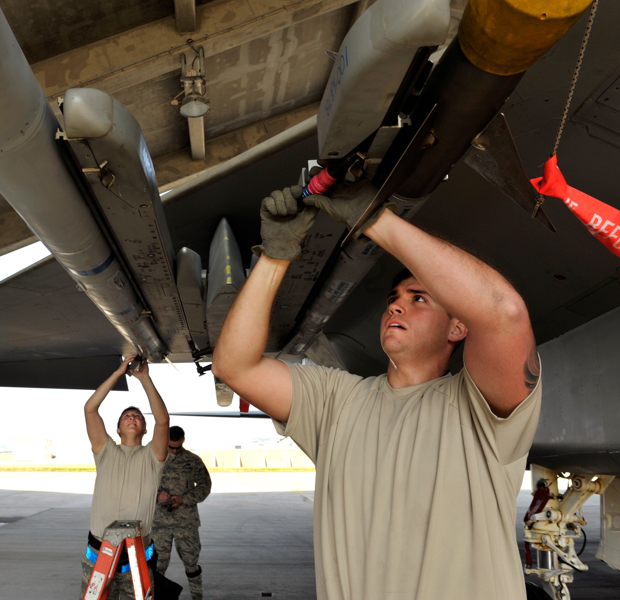 A U.S. Air Force weapons load crew team from the 44th Aircraft Maintenance Unit secures weapons onto an F-15 Eagle during a quarterly weapons load competition on Kadena Air Base, Japan, Jan. 5, 2015. The weapons load competition gives them a chance to showcase their skills and teamwork in front of their commander, peers, friends, family and supervision who cheer them on to move faster and more efficiently. (U.S. Air Force photo by Naoto Anazawa)