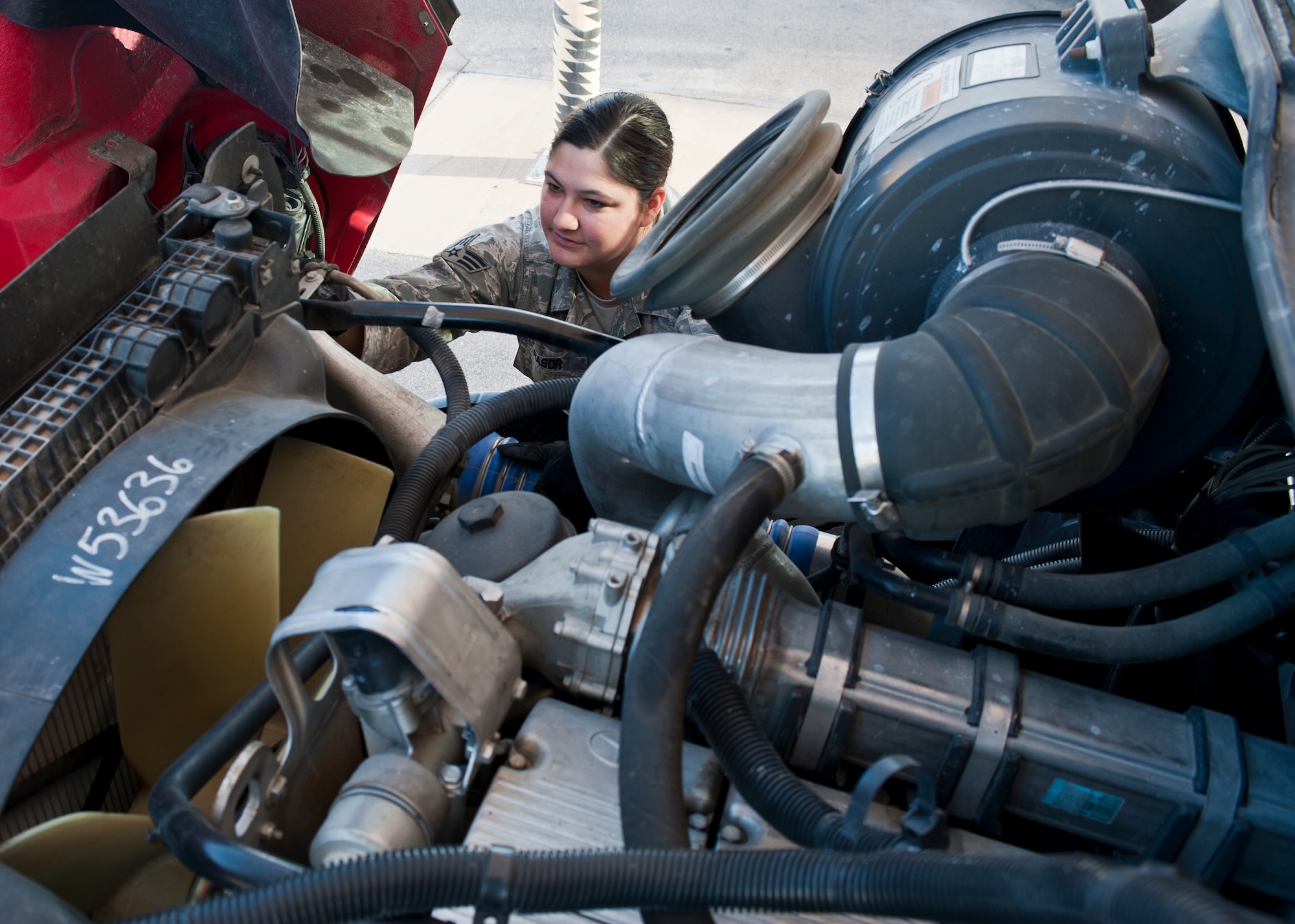 Senior Airman Megan Rasor, 99th Logistics Readiness Squadron vehicle operator, checks under the hood of a semi-truck during a maintenance check at the vehicle operations center on Nellis Air Force Base, Nev., Jan. 6, 2015. During the maintenance checks, vehicle operators are looking for signs of damage, wear and tear, or safety issues with the vehicles. (U.S. Air Force photo by Staff Sgt. Siuta B. Ika)