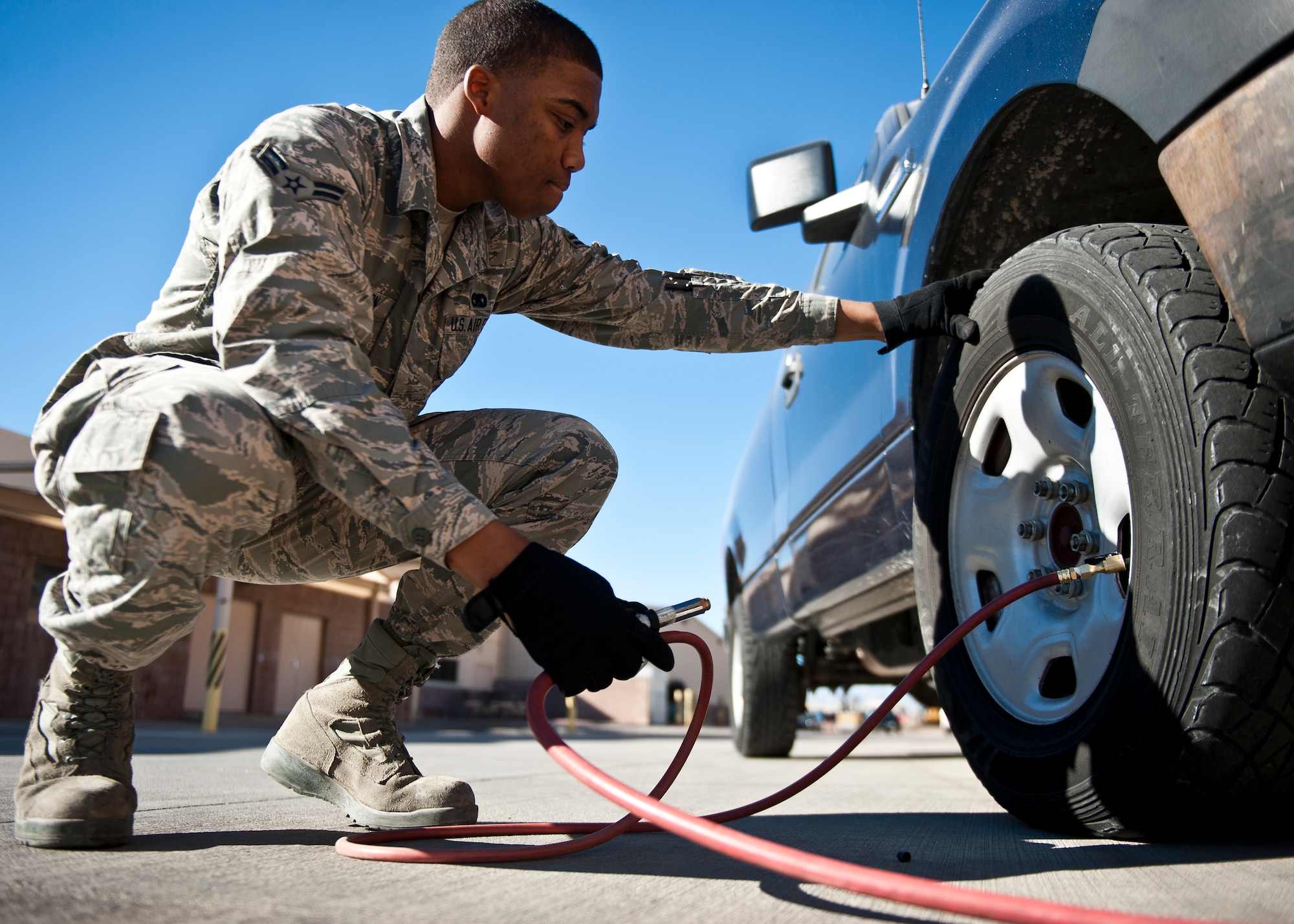 Airman 1st Class Marcus Johnson, 99th Logistics Readiness Squadron vehicle operator, services a flat tire with air at the vehicle operations center on Nellis Air Force Base, Nev., Jan. 6, 2015. Vehicle operators like Johnson help maintain the base’s vehicle fleet. (U.S. Air Force photo by Airman 1st Class Mikaley Towle)
