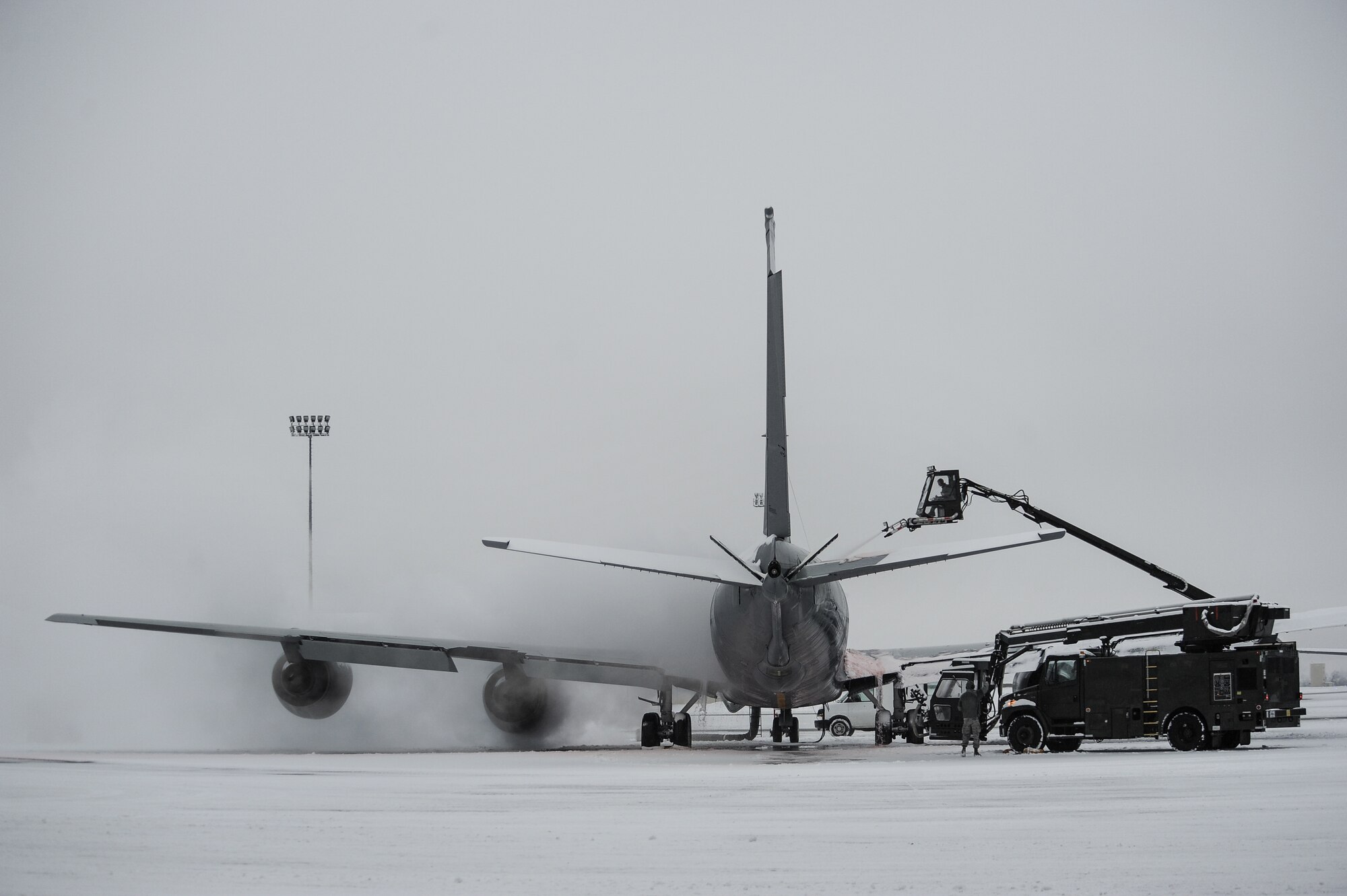 92nd Aircraft Maintenance Squadron Airmen work together to de-ice a KC-135 Stratotanker on the flight line for flight preparation at Fairchild Air Force Base, Wash., Jan. 29, 2014. Aircraft de-icing is a process in which liquid solutions are sprayed onto an aircraft during the winter to both defrost and prevent future precipitation from freezing. Snow and ice on the wings and rear tail component change their shape and disrupt the airflow making it difficult to fly and diminishes fuel economy. The recently installed deicing simulator allows Airmen to train deicing an aircraft without using costly deicing resources and equipment. (U.S. Air Force photo/Staff Sgt. Alexandre Montes)