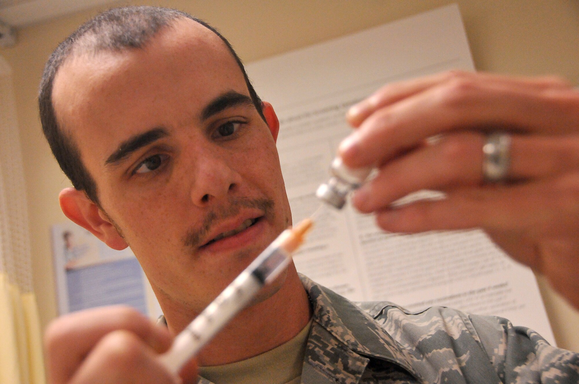 Senior Airman Robert Davis, immunization back-up technician with the 403rd ASTS, draws vaccine from a vial for a flu shot given during the Unit Training Assembly Dec. 6, here. Members of the ASTS occupy the Keesler hospital during UTA weekends to provide medical services to members of the 403rd Wing. (U.S. Air Force photo/Senior Airman Nicholas Monteleone)