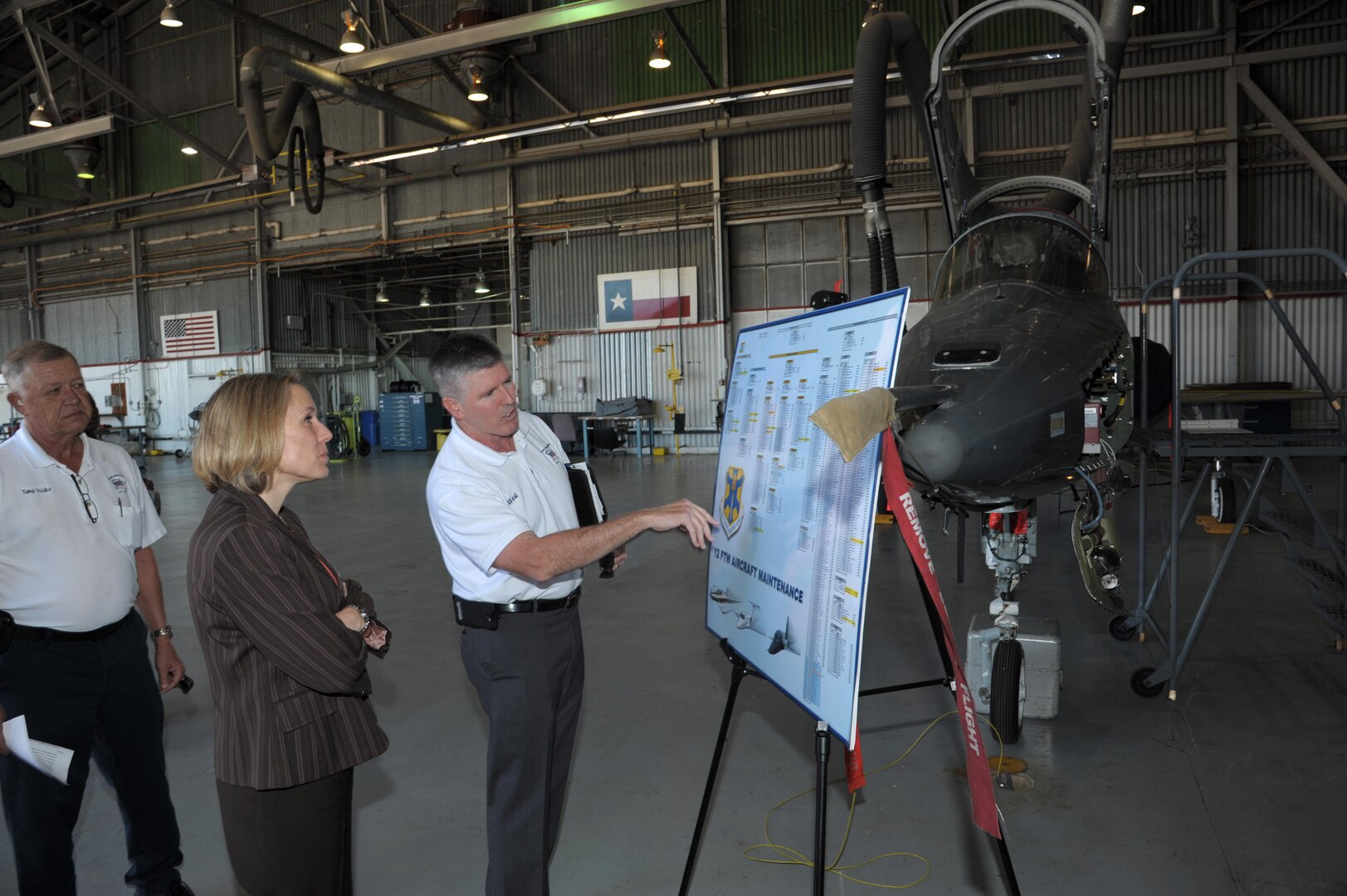 Bob West (right), 12th Flying Training Wing director of maintenance, briefs Miranda Ballentine (left), Assistant Secretary of the Air Force for Installations, Environment and Energy, Dec. 15 on fuels systems during her tour at JBSA-Randolph. (U.S. Air Force photo by Joel Martinez)