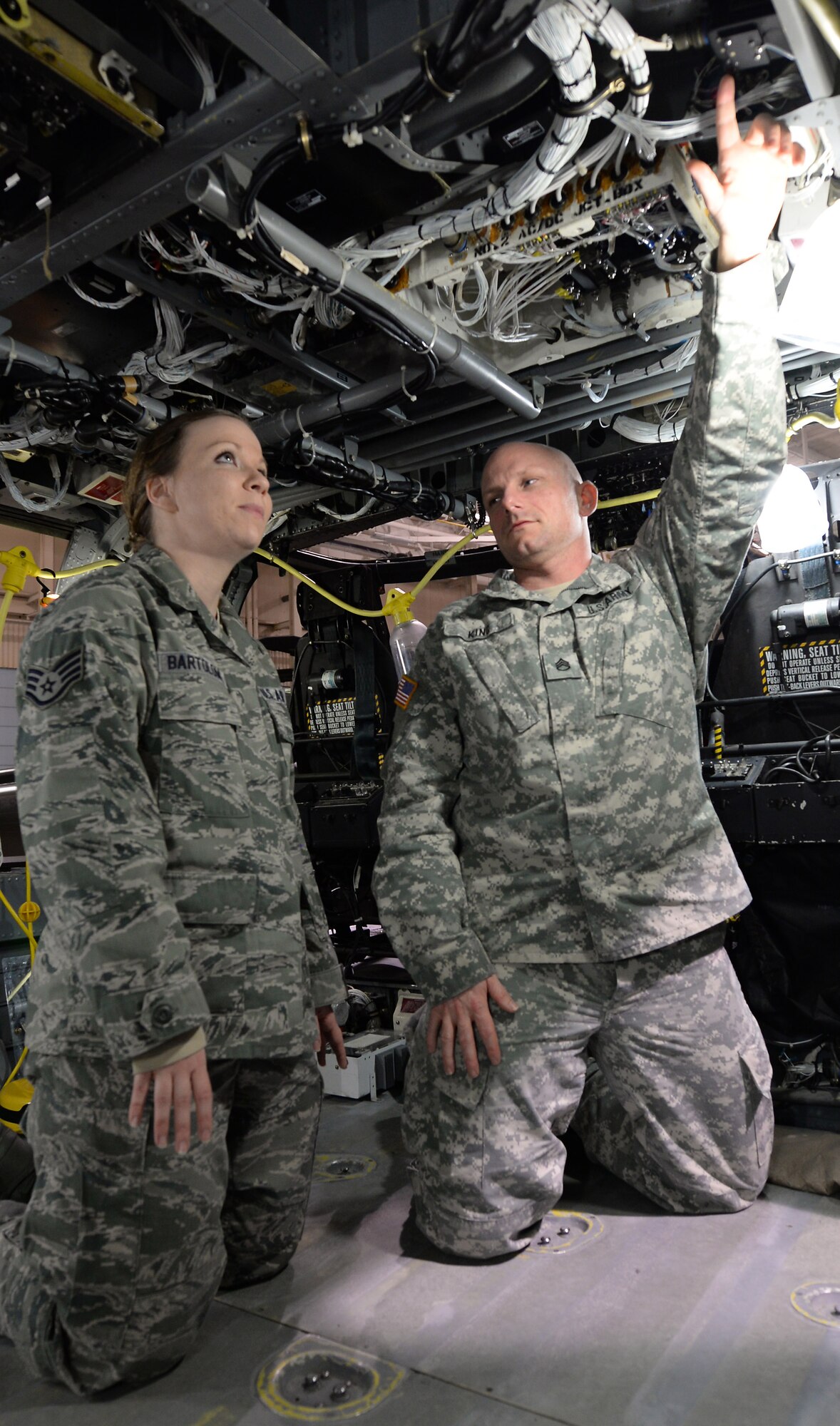 U.S. Army Staff Sgt. Joseph King, Charlie Company, 1st Battalion, 210th Aviation Regiment, 128th Aviation Brigade instructor, shows possible safety hazards instructors must point out to all Advanced Individual Training students to U.S. Air Force Staff Sgt. Maegann Bartolome, 633rd Air Base Wing Safety ground safety technician, at Fort Eustis, Va., Jan. 5, 2014. Bartolome’s New Year’s resolution is to become more versed in the Army safety regulations and requirements she will inspect throughout the year. Air Force Safety personnel on Joint Base Langley-Eustis must perform on-the-job training at Fort Eustis to learn Army safety regulations. (U.S. Air Force photo by Staff Sgt. Teresa J. Cleveland/Released)